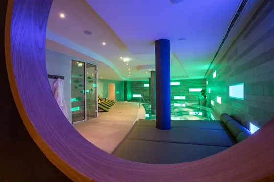 Indoor-Pool des meerspa mit blauem Licht und großen Fenstern